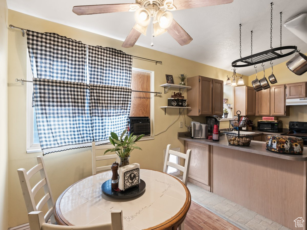 Dining room with light hardwood / wood-style floors, ceiling fan, and cooling unit