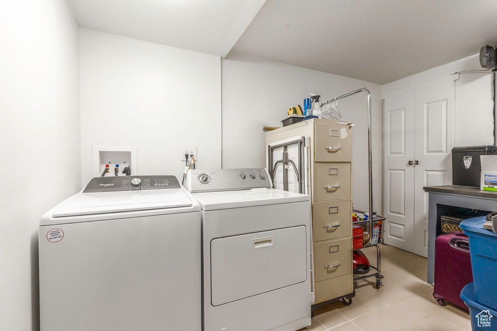 Laundry area featuring washer and clothes dryer and light tile patterned floors