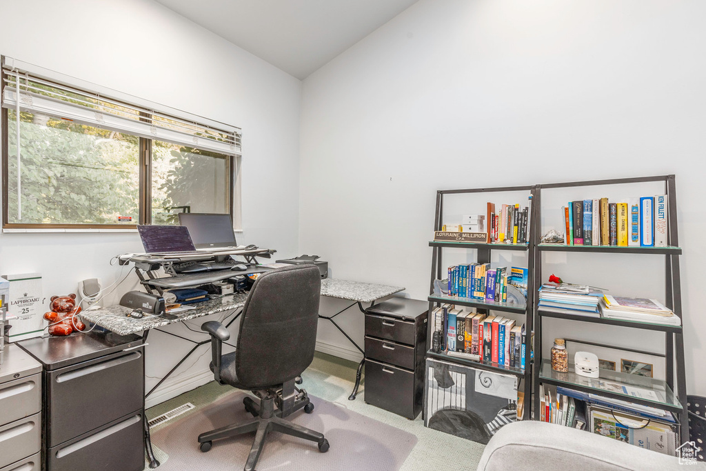 Carpeted office featuring lofted ceiling