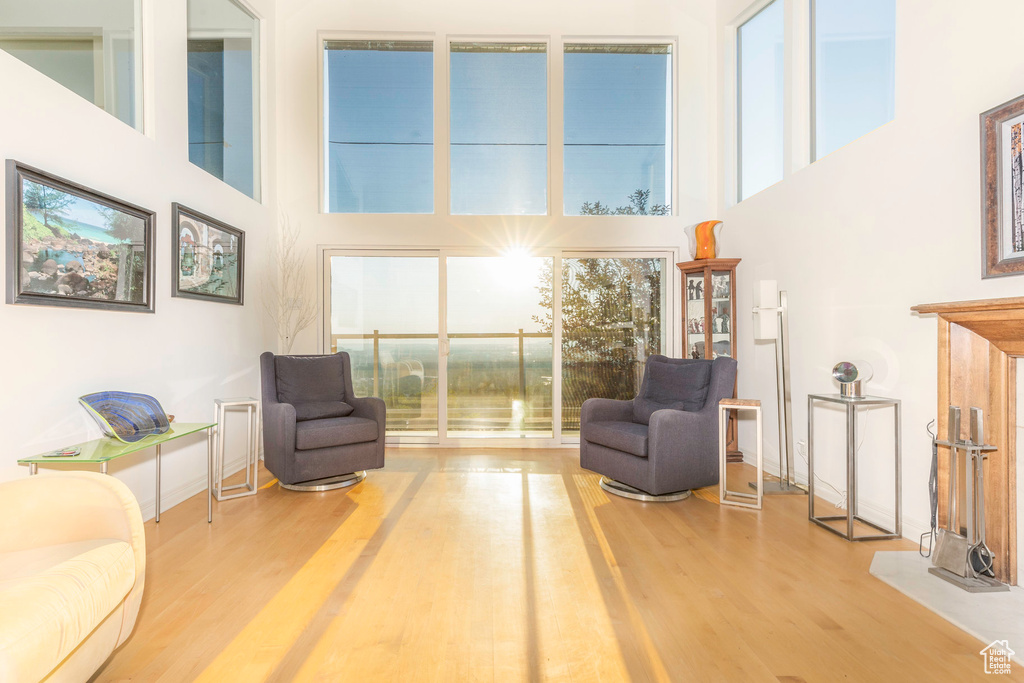 Sitting room featuring light hardwood / wood-style flooring and a towering ceiling