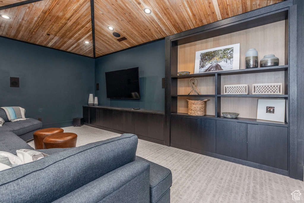 Carpeted living room with built in features and wood ceiling