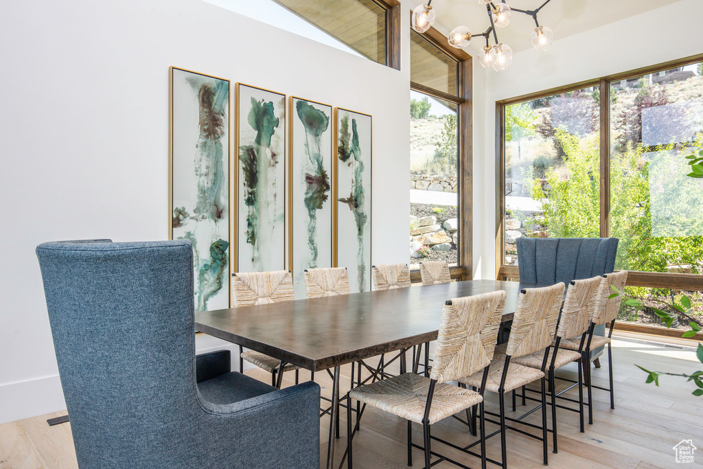 Dining space featuring light hardwood / wood-style flooring, an inviting chandelier, and lofted ceiling