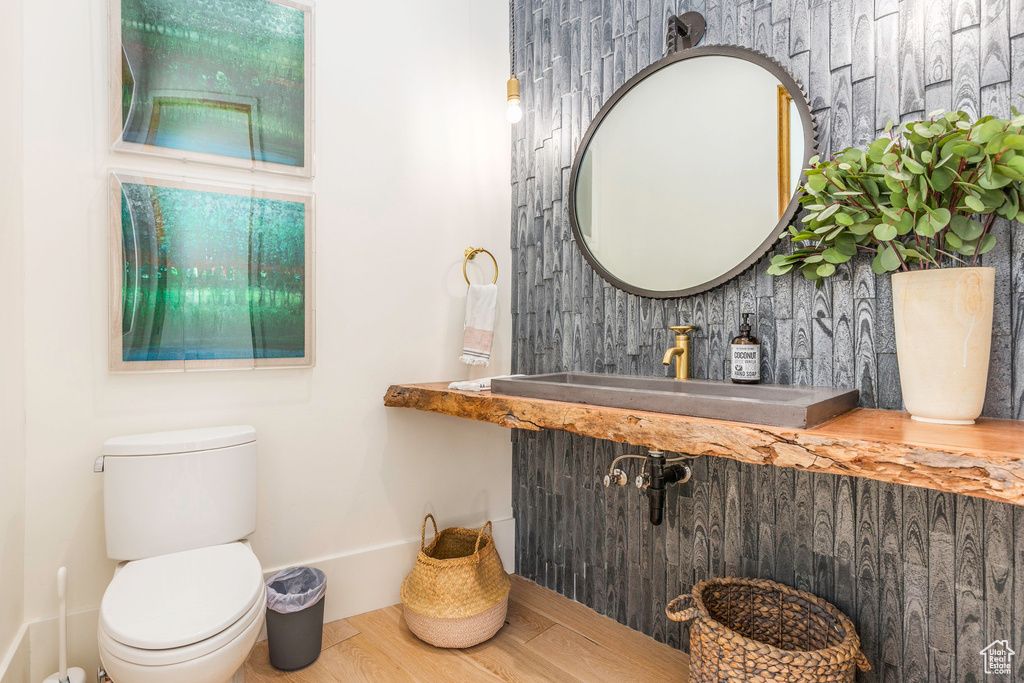 Bathroom featuring hardwood / wood-style floors, sink, and toilet