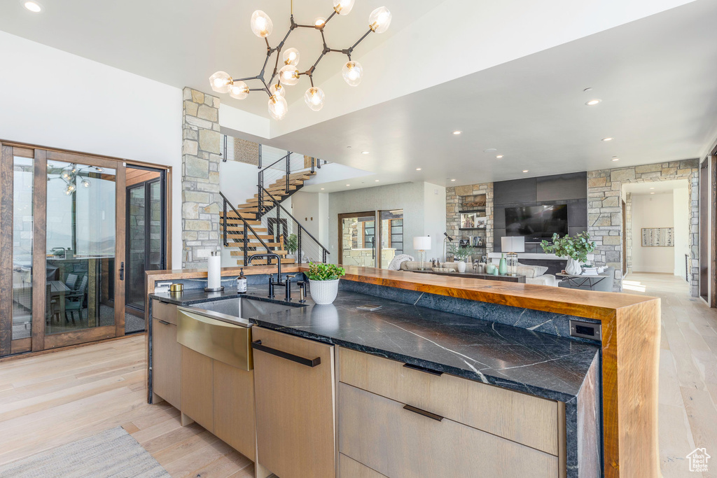 Kitchen with a chandelier, light brown cabinetry, sink, and light wood-type flooring