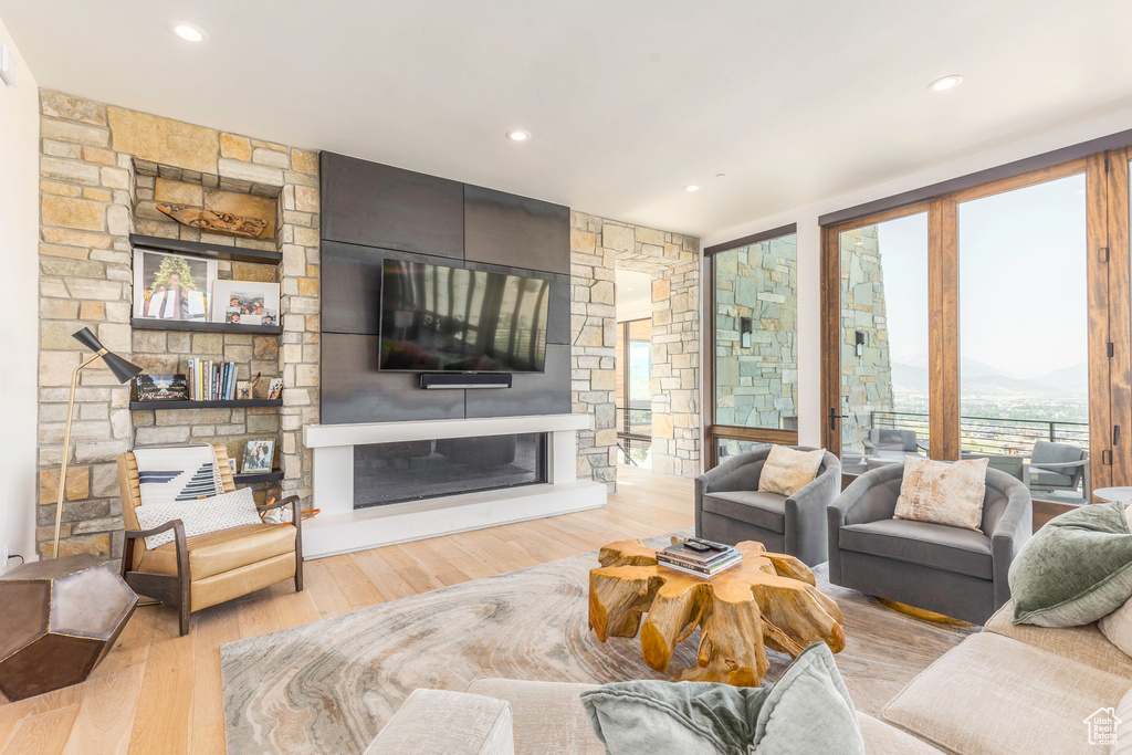 Living room featuring a stone fireplace and light wood-type flooring