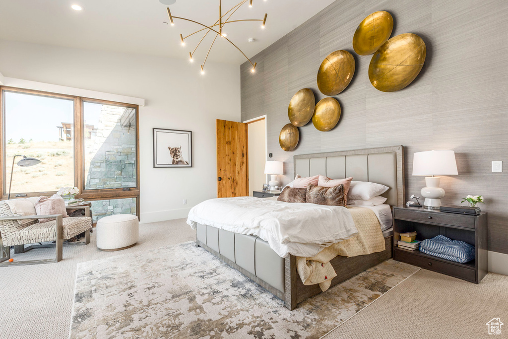 Bedroom featuring a notable chandelier, lofted ceiling, and light colored carpet