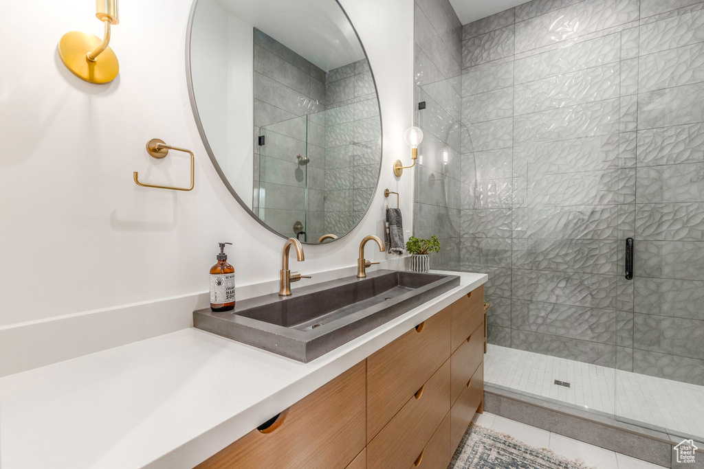 Bathroom with a shower with shower door, vanity, and tile patterned floors