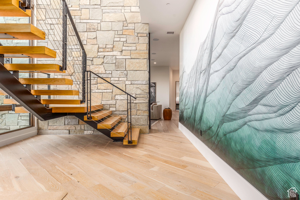 Stairway featuring hardwood / wood-style flooring