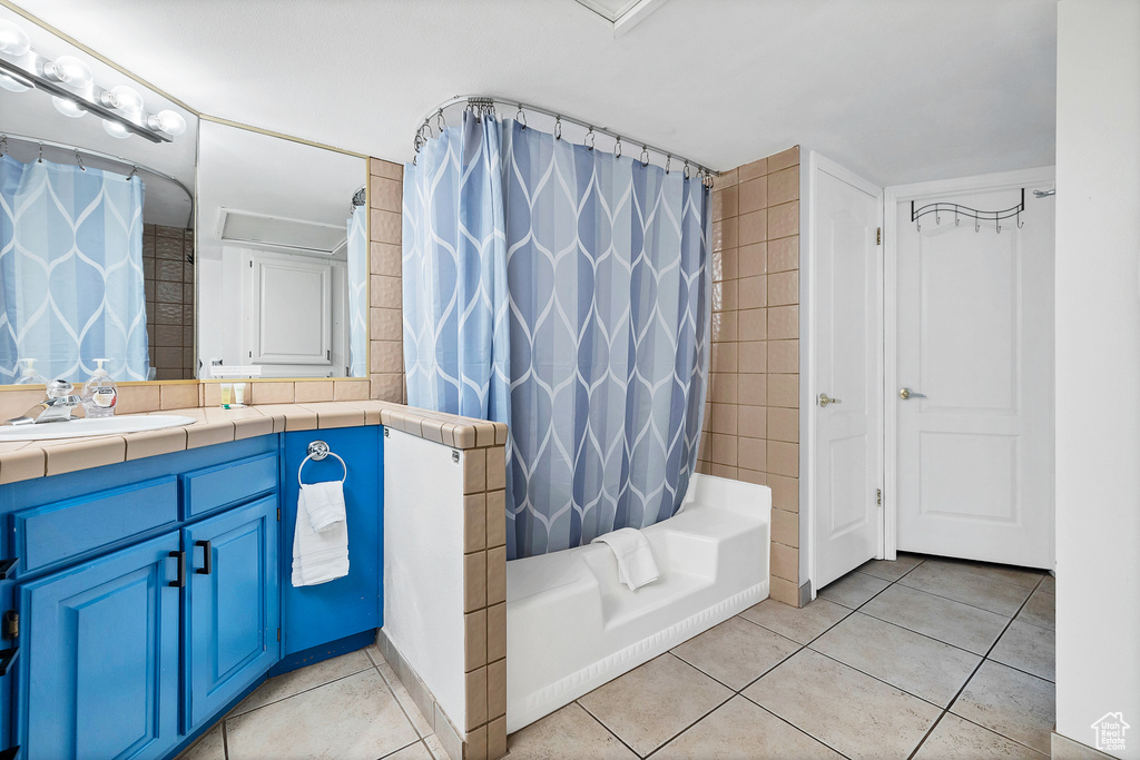 Bathroom with tile patterned flooring, shower / tub combo, and vanity