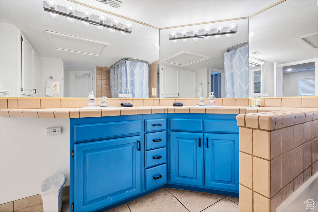 Bathroom featuring tile patterned flooring and double sink vanity