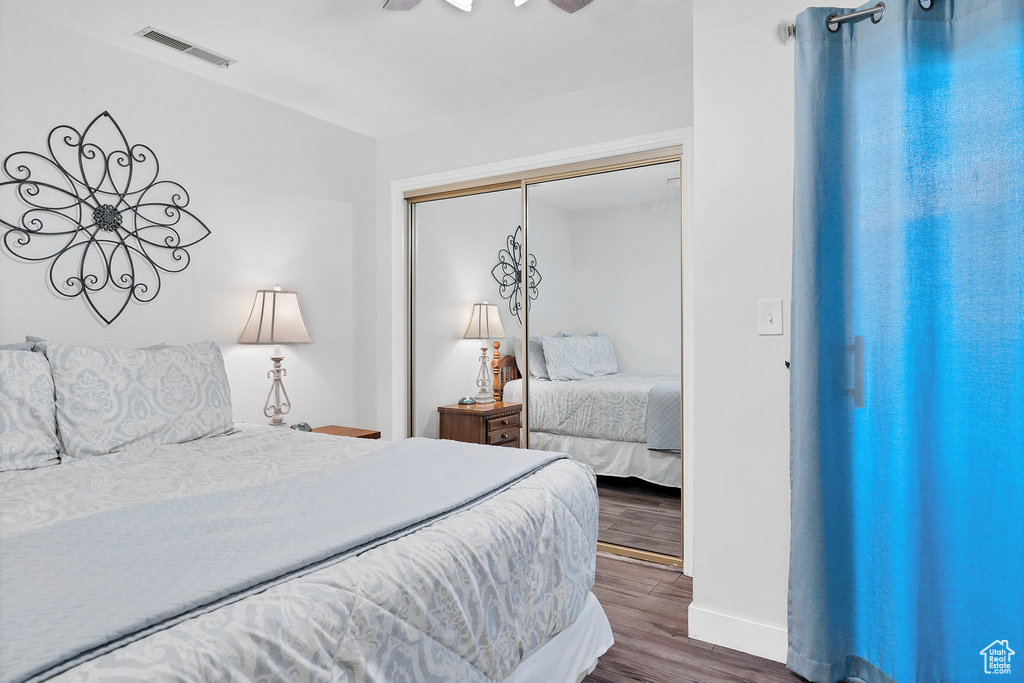 Bedroom with ceiling fan, a closet, and hardwood / wood-style flooring