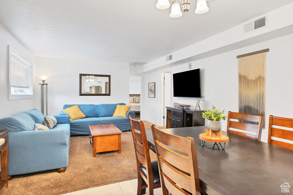 Living room featuring light tile patterned flooring and a notable chandelier