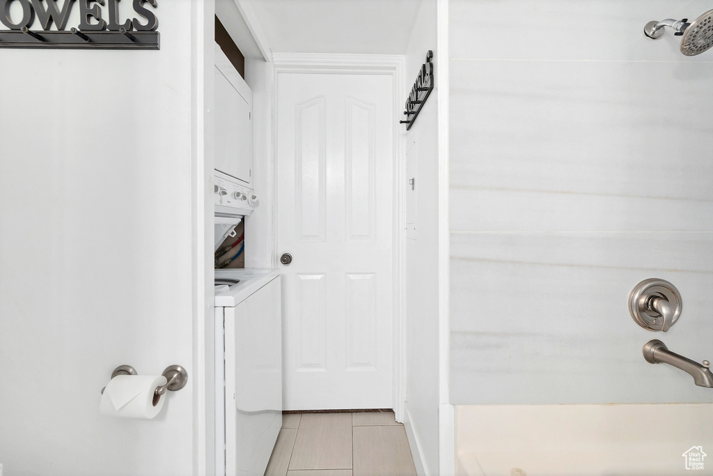 Bathroom with stacked washer and dryer and tile patterned floors