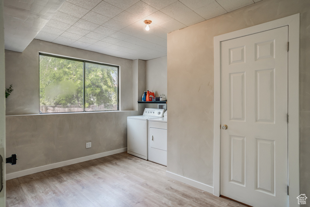 Clothes washing area featuring light hardwood / wood-style floors and separate washer and dryer