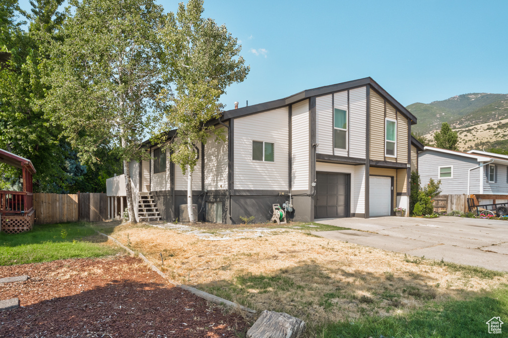 View of front of property with a garage and a mountain view