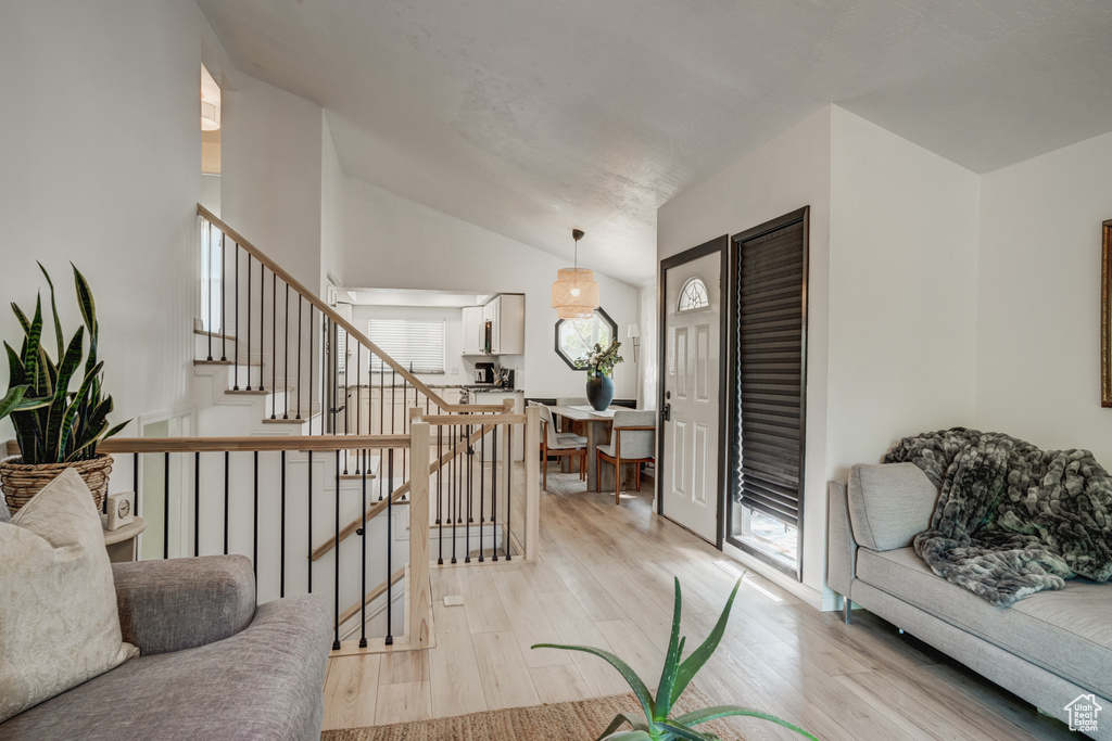 Living room with vaulted ceiling and light wood-type flooring