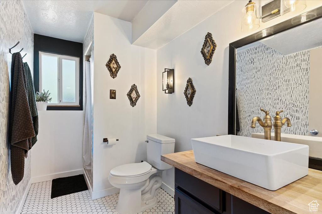 Bathroom featuring vanity, tile patterned flooring, and toilet