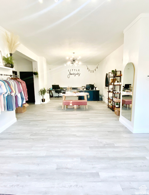 Interior space with lofted ceiling, light hardwood / wood-style floors, and an inviting chandelier