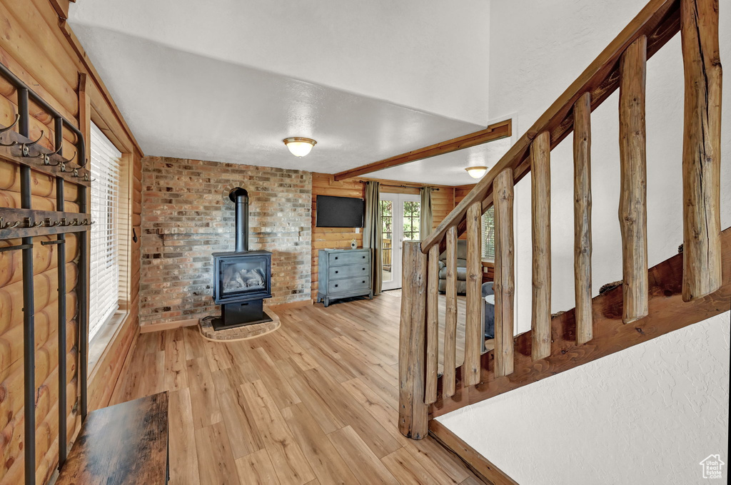 Foyer entrance featuring a wood stove, light hardwood / wood-style floors, and brick wall