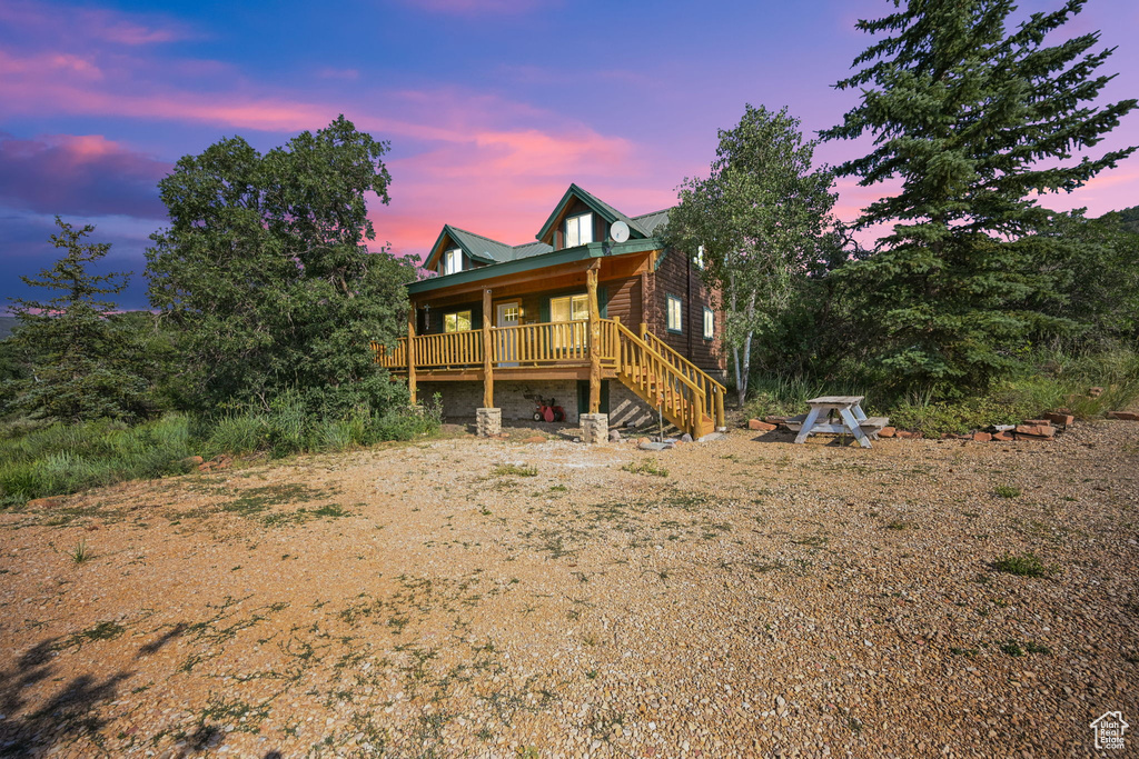 Back house at dusk featuring a wooden deck