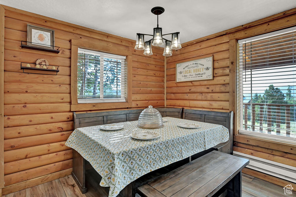 Bedroom featuring light hardwood / wood-style flooring, multiple windows, and log walls