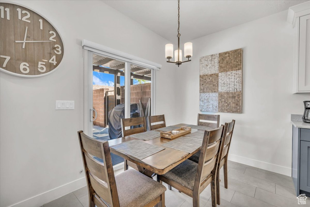 Dining space with a notable chandelier and light tile patterned floors