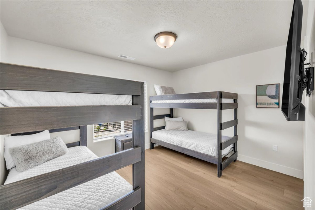 Bedroom featuring light hardwood / wood-style flooring and a textured ceiling