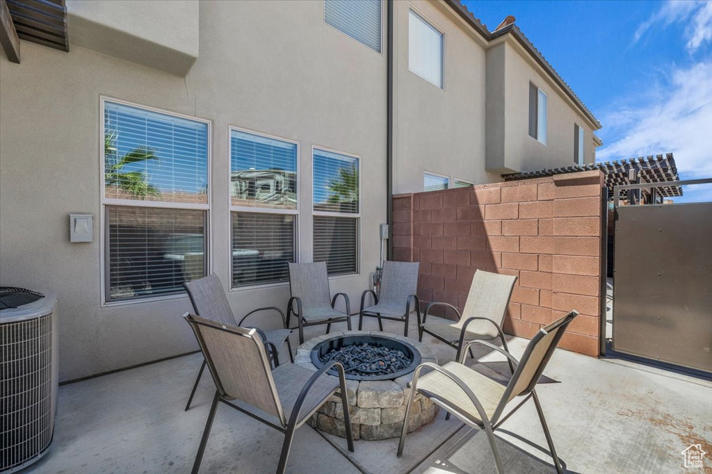 View of patio with central AC and an outdoor fire pit