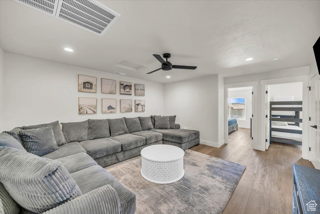 Living room with ceiling fan and light hardwood / wood-style flooring