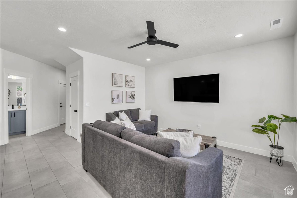 Tiled living room featuring ceiling fan