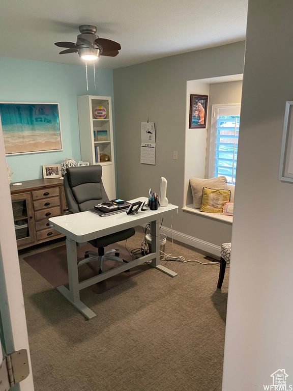 Carpeted office featuring ceiling fan