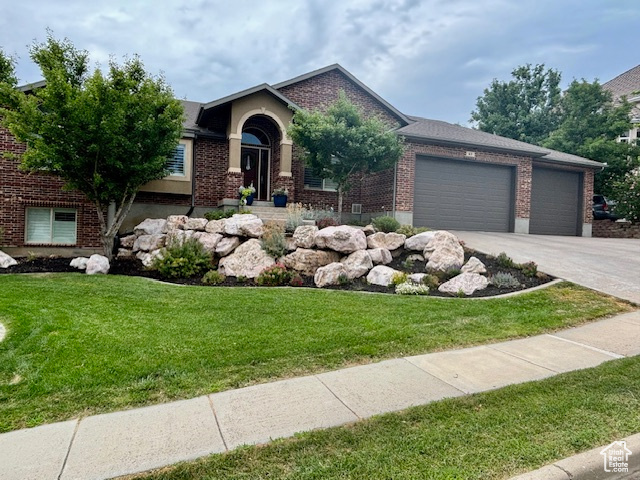 View of front of house featuring a garage and a front lawn