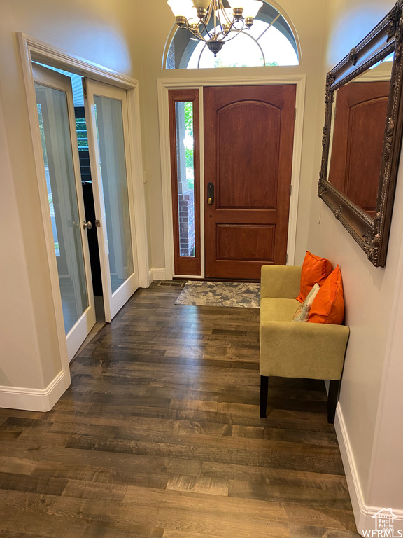 Entryway with dark hardwood / wood-style floors and a chandelier