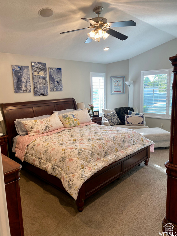 Bedroom with vaulted ceiling, ceiling fan, and carpet flooring