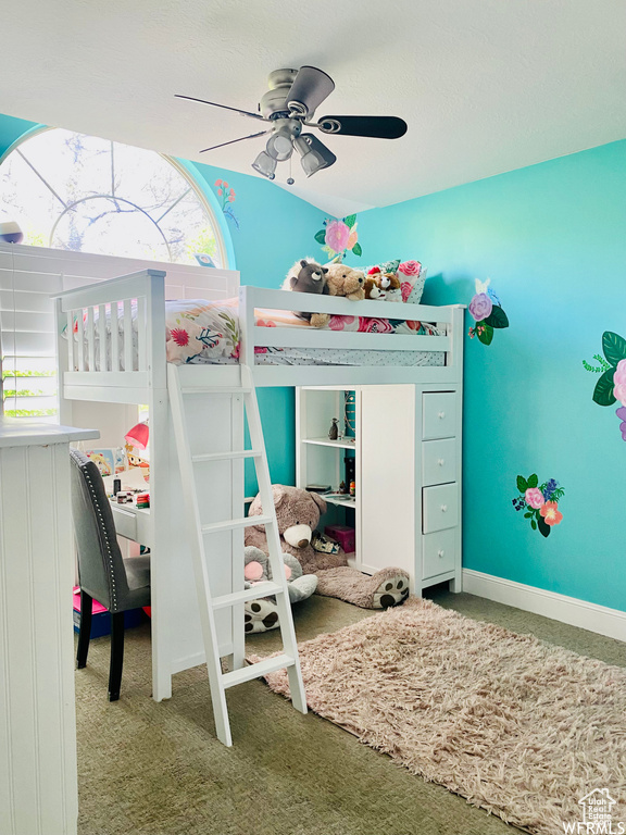 Carpeted bedroom with multiple windows and ceiling fan