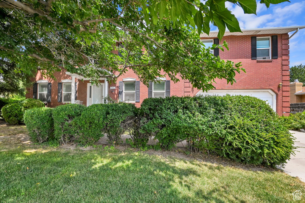 View of front of home featuring a garage and a front lawn