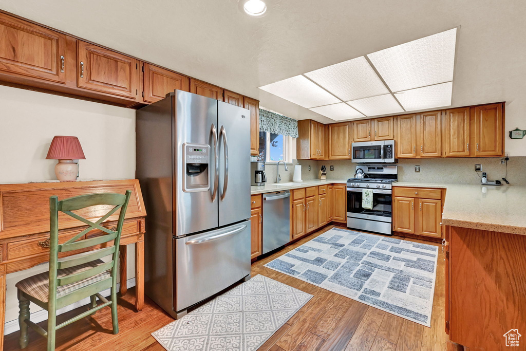 Kitchen with sink, light wood-type flooring, and stainless steel appliances