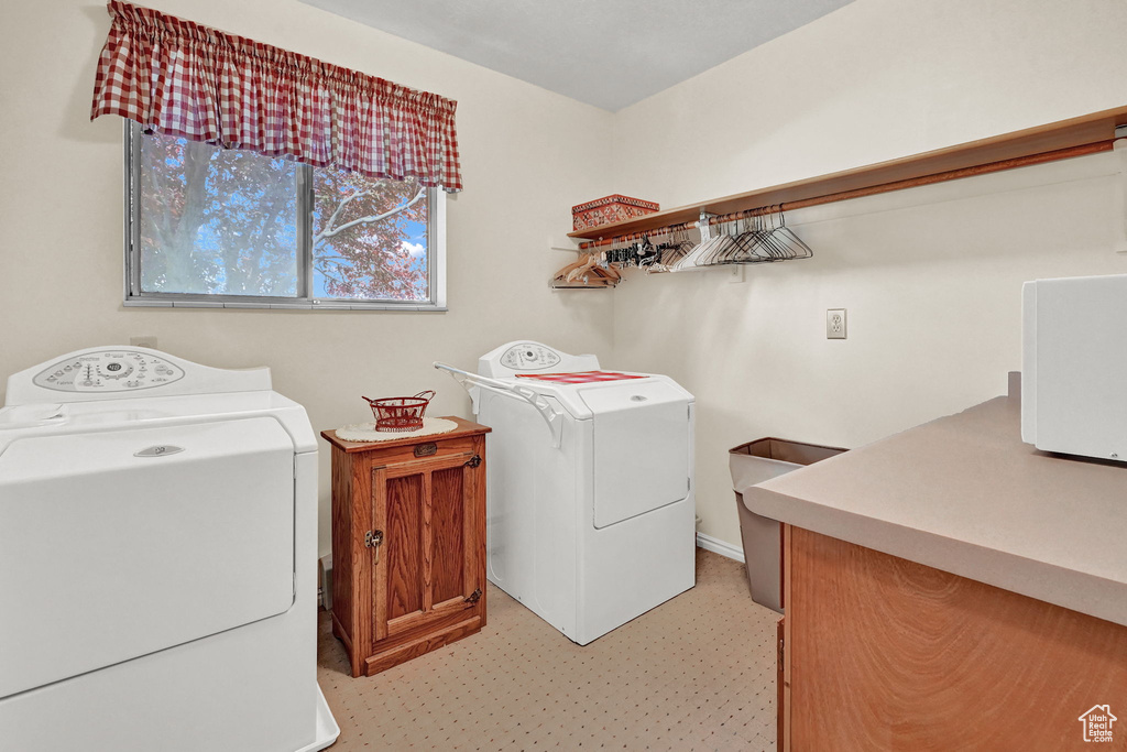 Laundry area featuring washing machine and dryer and light colored carpet