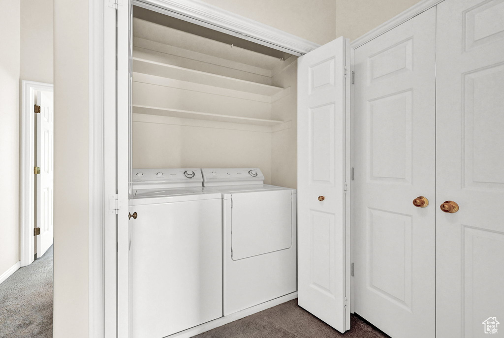 Washroom featuring dark carpet and separate washer and dryer