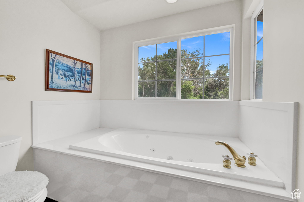 Bathroom with a tub to relax in and toilet