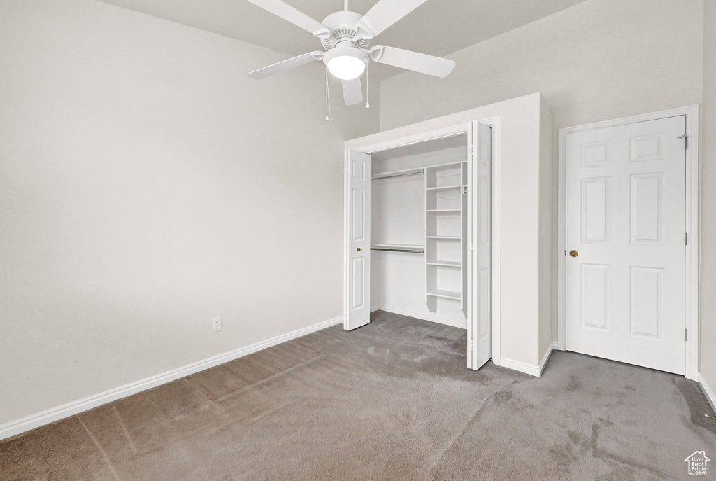 Unfurnished bedroom featuring a closet, carpet, and ceiling fan