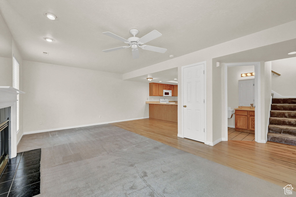 Unfurnished living room featuring ceiling fan and light wood-type flooring