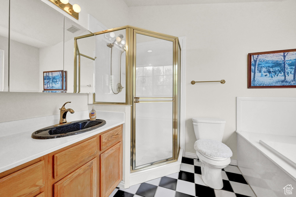 Full bathroom featuring vanity, plus walk in shower, toilet, and tile patterned floors