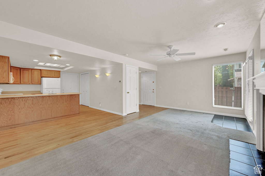 Unfurnished living room featuring light hardwood / wood-style flooring and ceiling fan