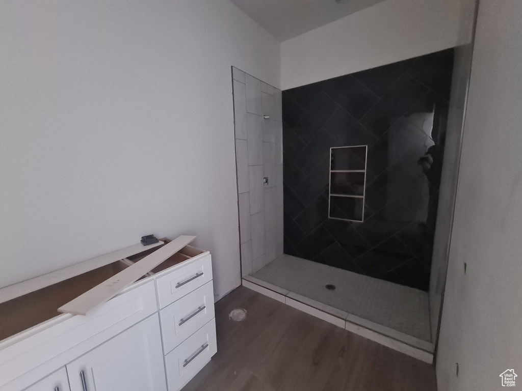 Bathroom featuring a tile shower and hardwood / wood-style floors