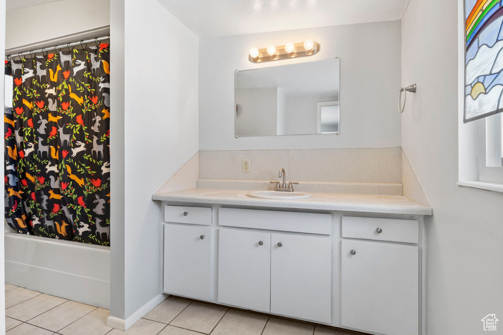 Bathroom with shower / tub combo with curtain, vanity, and tile patterned flooring