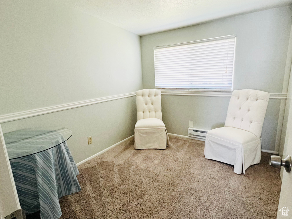 Sitting room with a baseboard heating unit and carpet floors