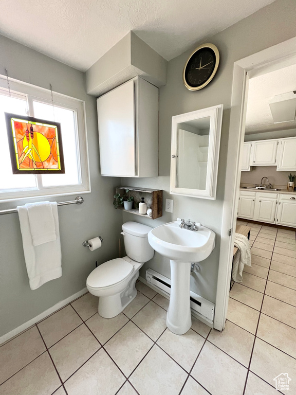 Bathroom featuring sink, a textured ceiling, toilet, and tile patterned flooring