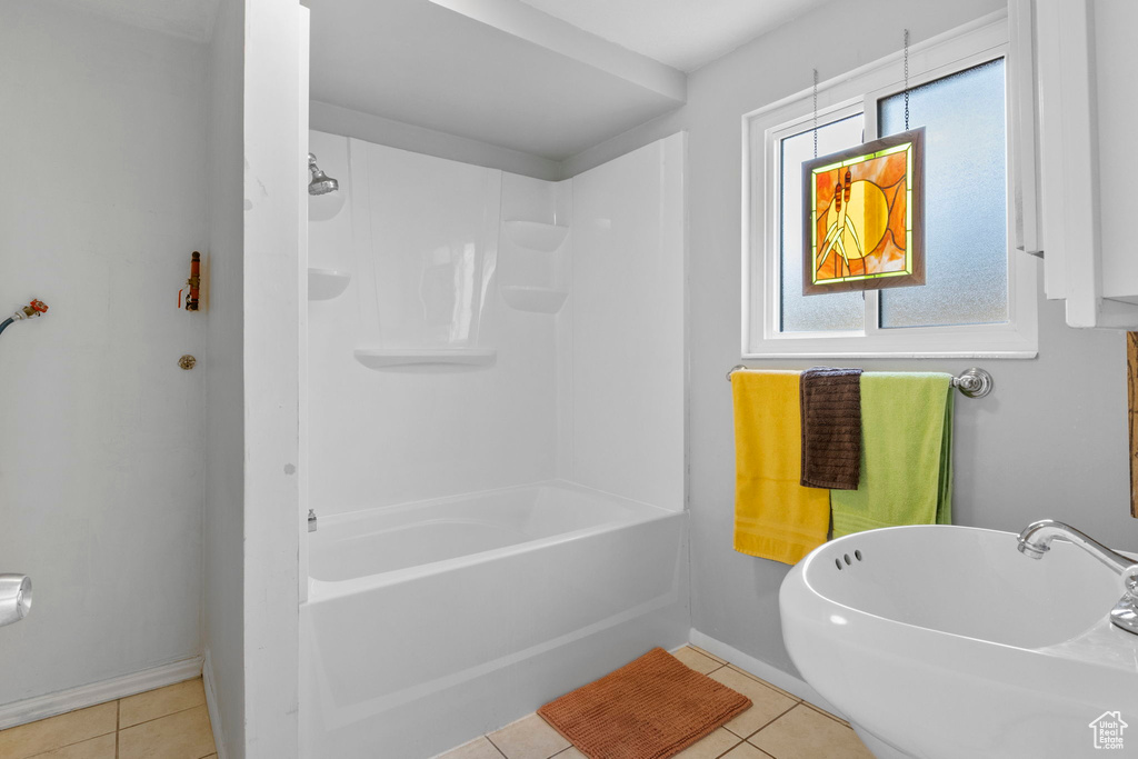 Bathroom featuring shower / bathtub combination, sink, tile patterned floors, and a wealth of natural light