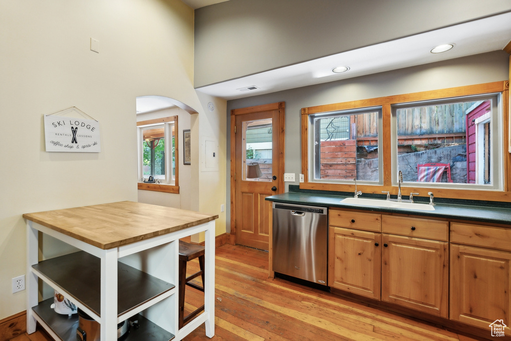 Kitchen with butcher block counters, light hardwood / wood-style flooring, sink, and stainless steel dishwasher